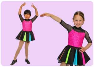 Two smiling girls in bright pink leopard print dance outfits with black mesh sleeves and multicolored skirts posing mid dance against a lavender background